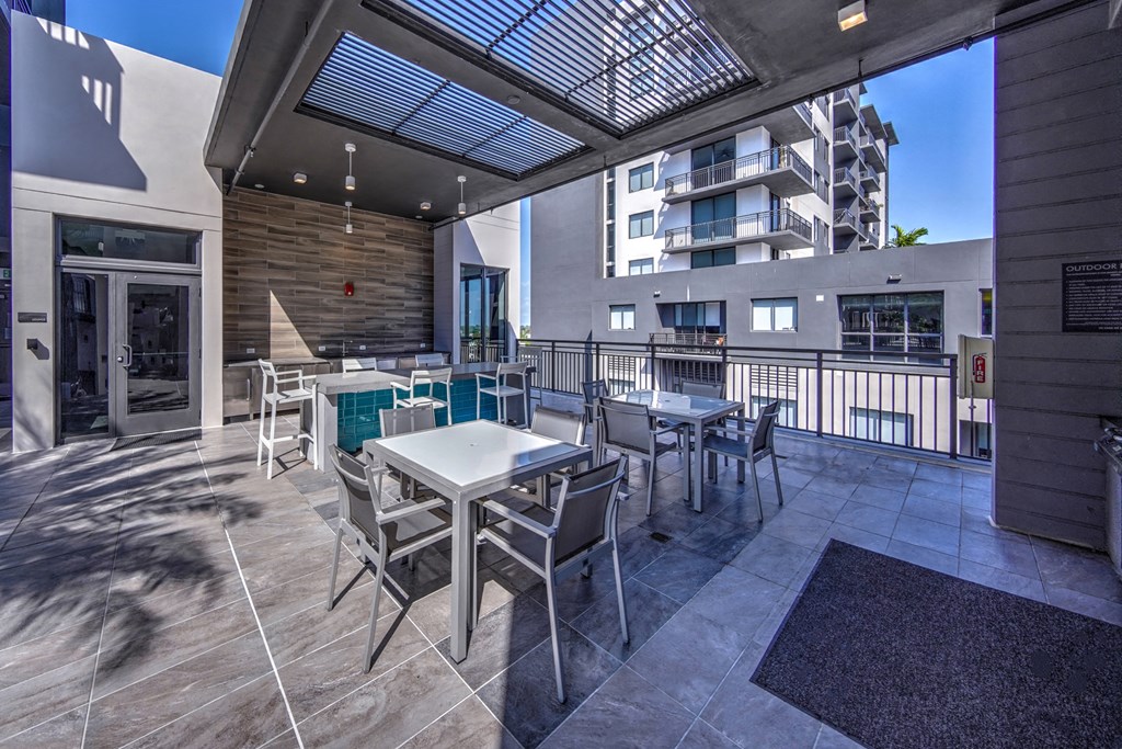 a patio with tables and chairs and a balcony