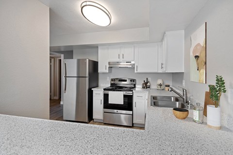 a kitchen with white cabinets and stainless steel appliances