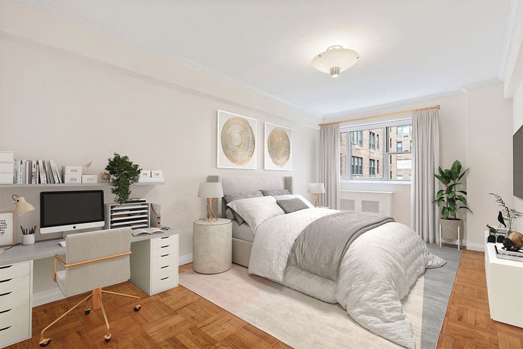 a bedroom with a bed and a desk in a room