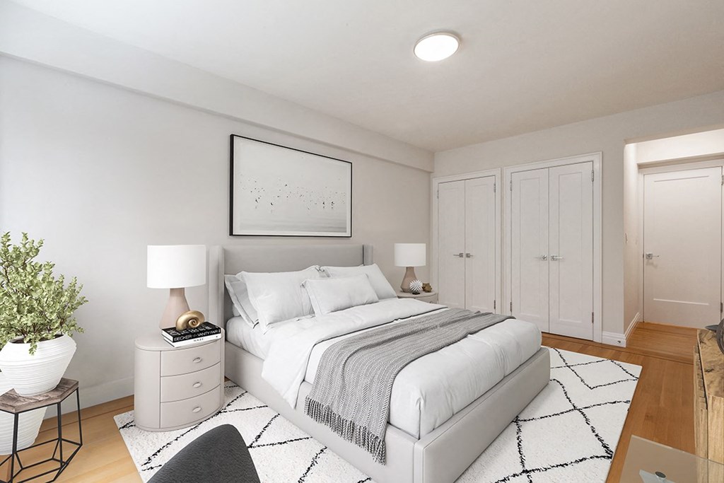 a bedroom with a white bed and a white rug