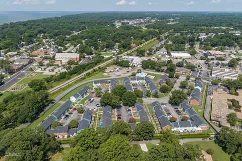 A bird's eye view of a large parking lot surrounded by buildings and trees.