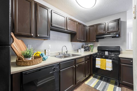 a kitchen with black appliances and dark wood cabinets