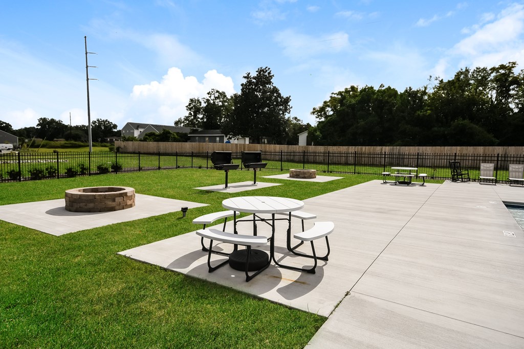 A picnic area with tables and a fire pit.