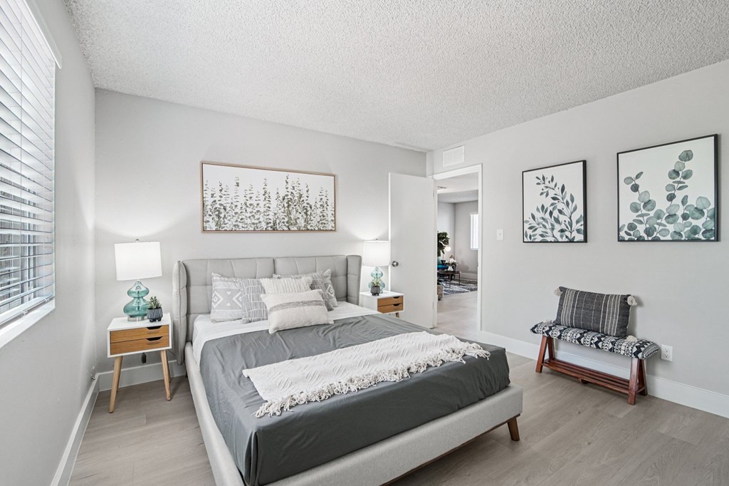 A bedroom with a large bed and two nightstands.