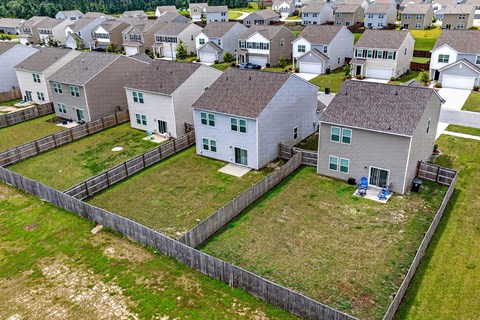 A row of houses with a fence in front of them.