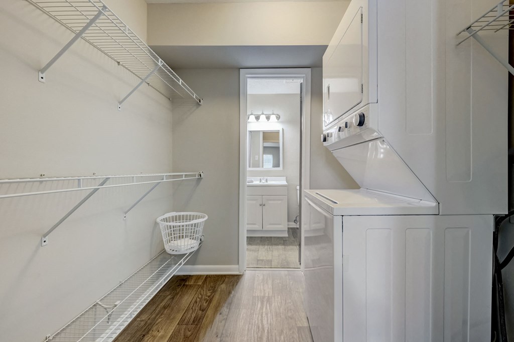Apartments In Sandy Springs, GA for Rent – Celebration at Sandy Springs - a walk in closet with white walls and shelves and a door to a bathroom