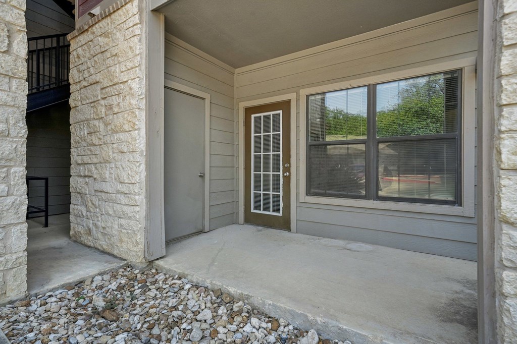 A house entrance with a brown door and a window.