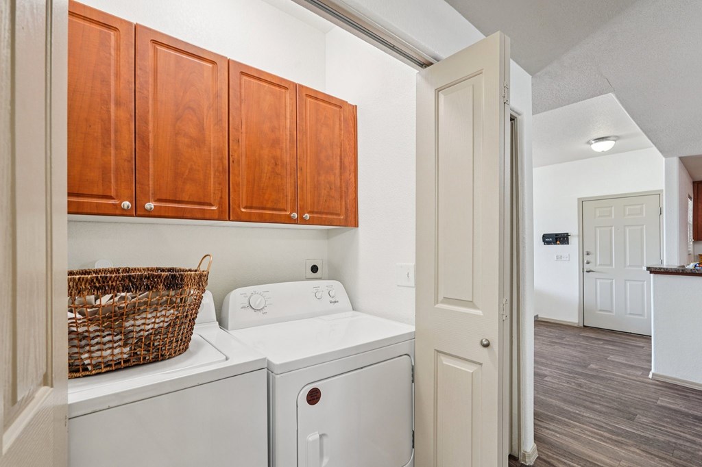 A laundry room with a basket on top of the washer and dryer.