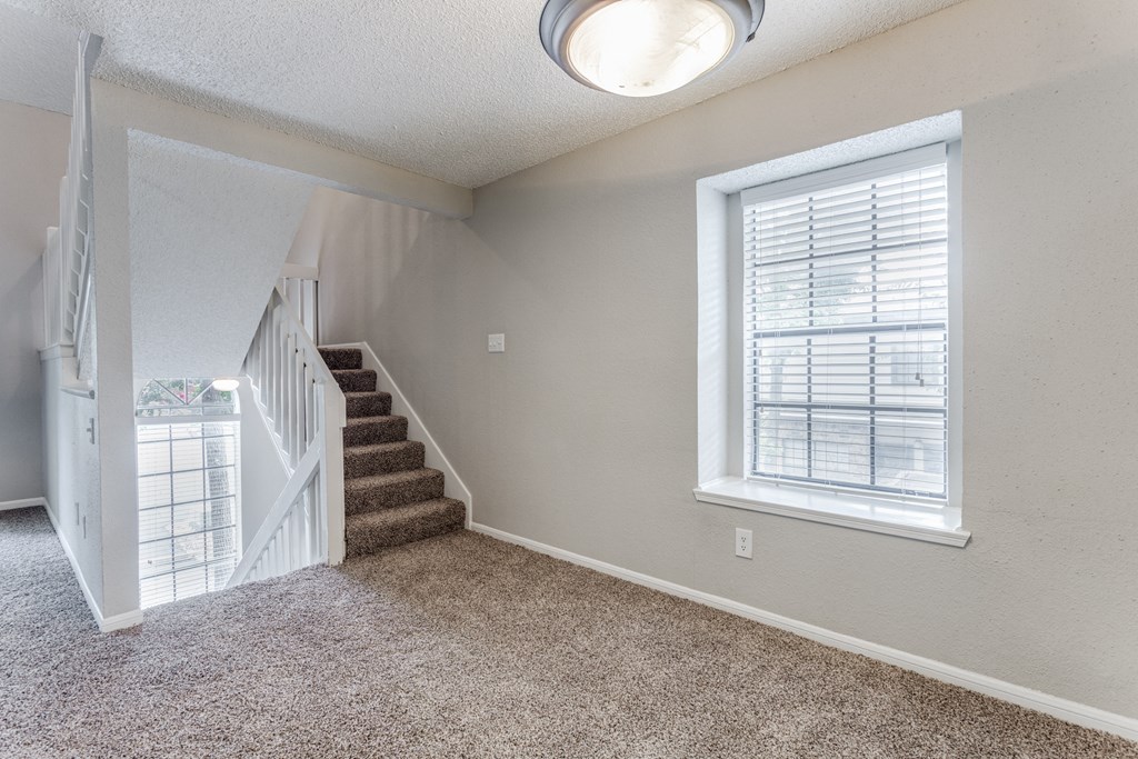 a bedroom with a staircase and a large window