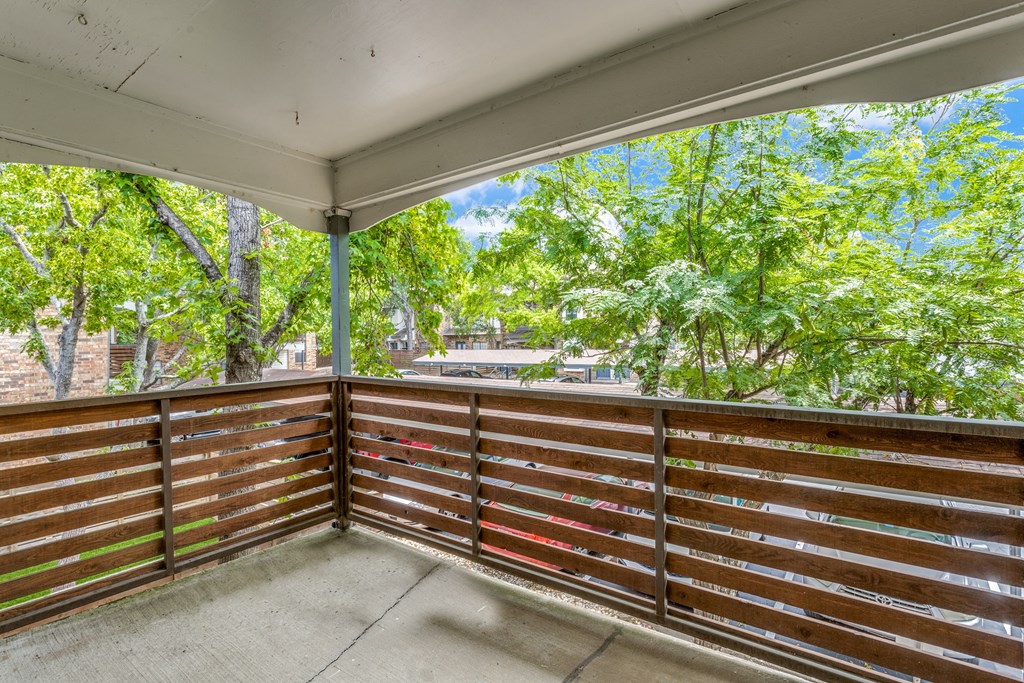 a large covered patio with trees in the background