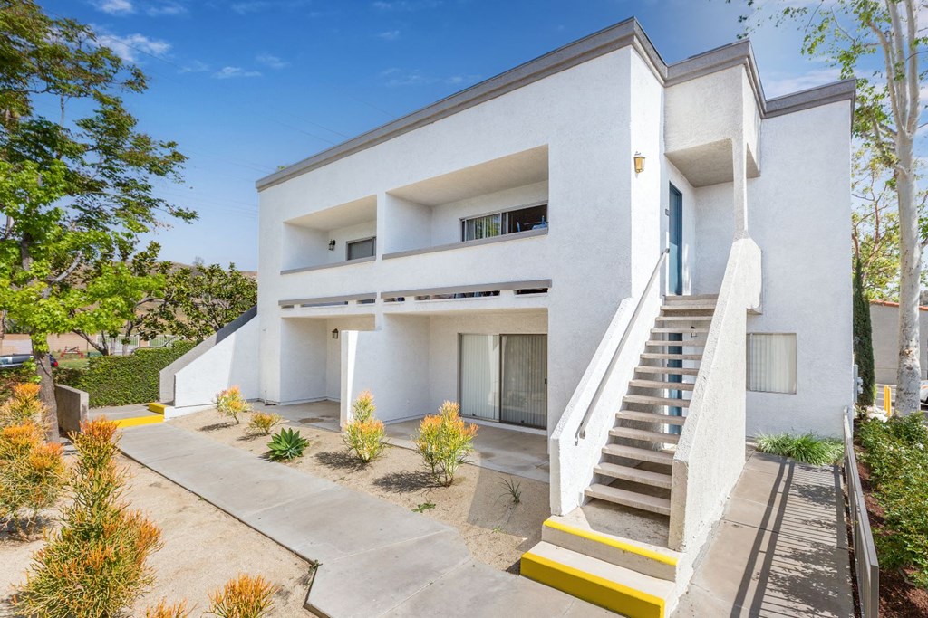 a white building with stairs and a blue door