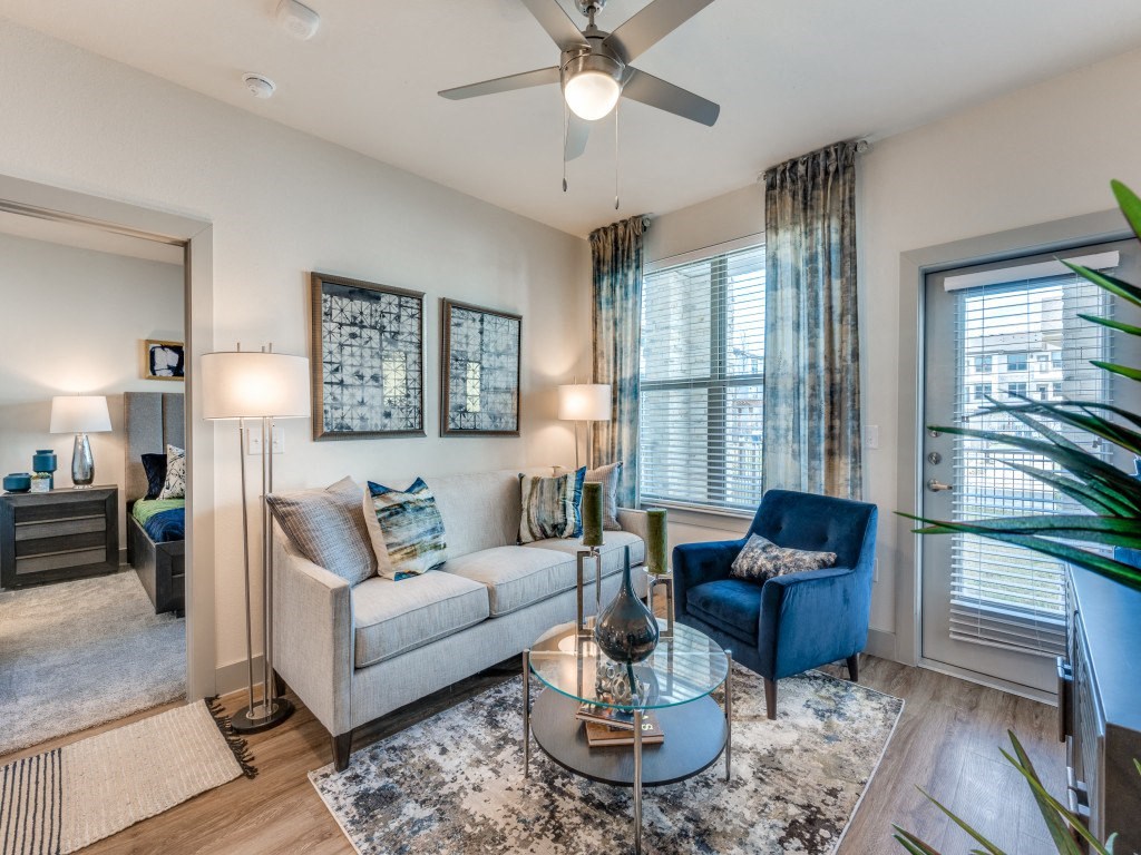 a living room with a couch and a chair and a ceiling fan