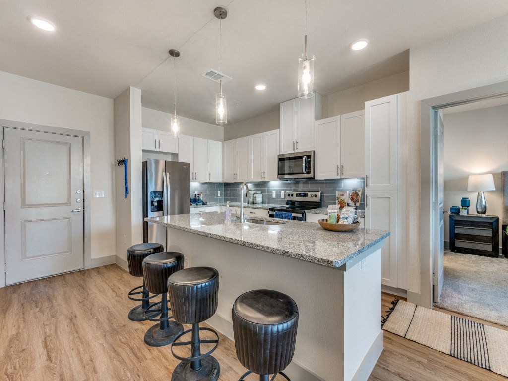 a kitchen with a bar and stools in front of a counter top