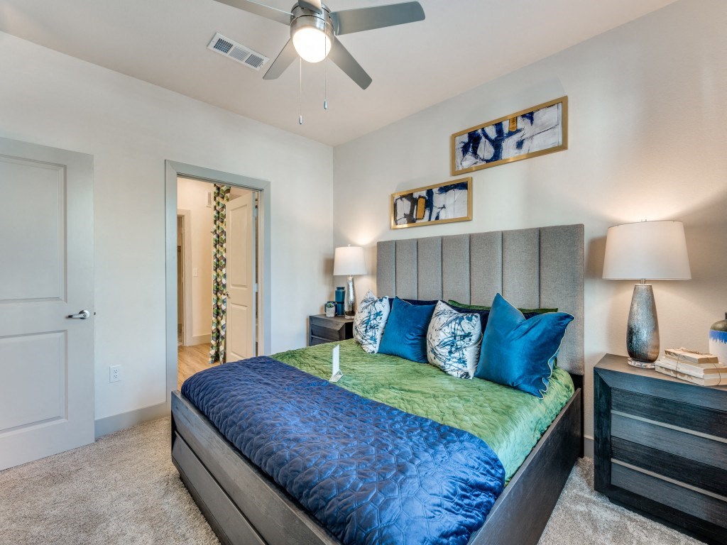 a bedroom with a large bed and a ceiling fan