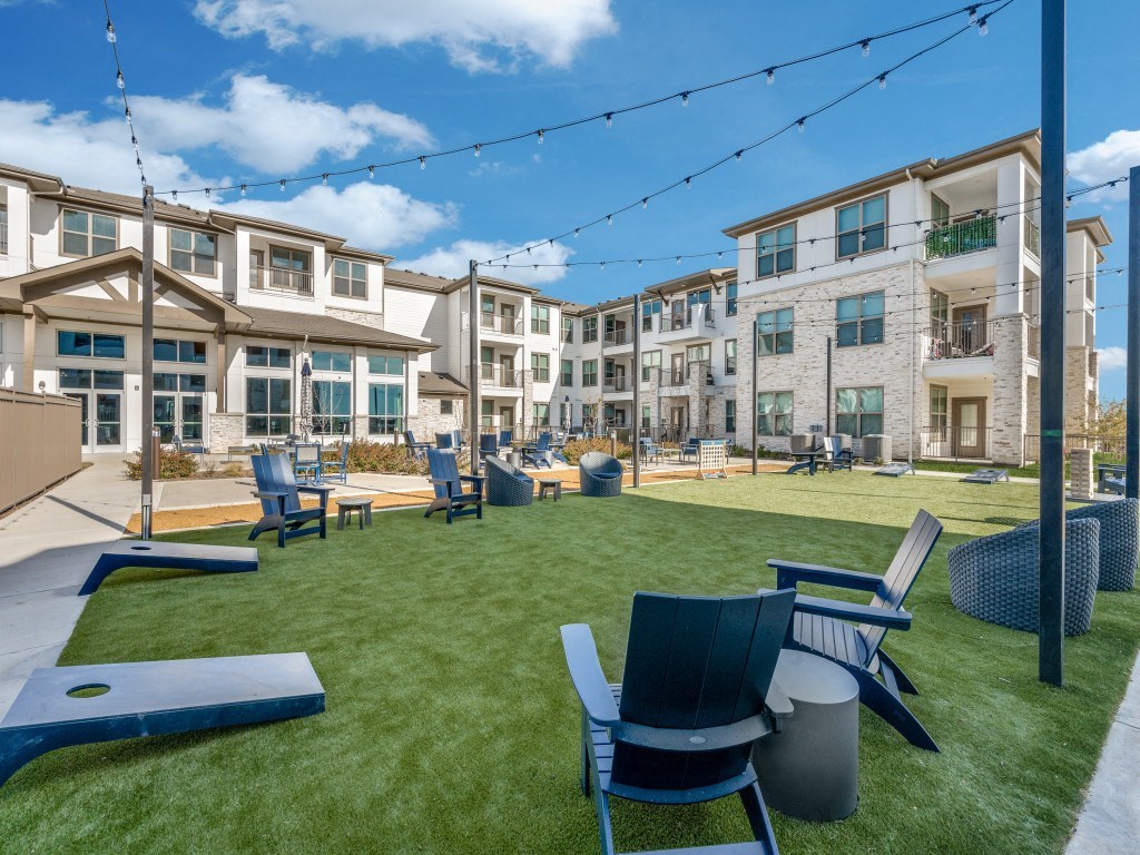 an outdoor patio with chairs and tables and buildings