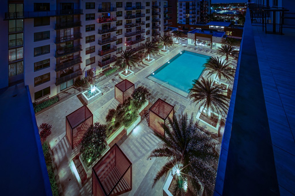 a night view of a pool in a hotel with palm trees