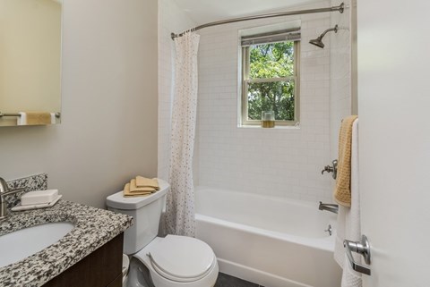 A white bathroom with a toilet, sink, and bathtub.