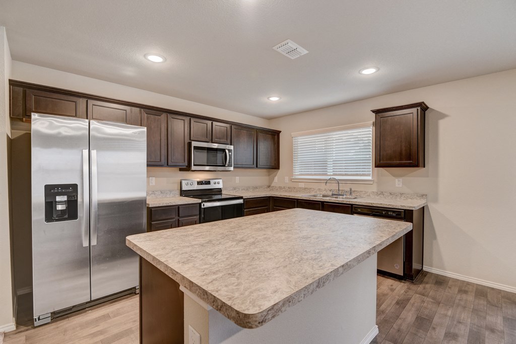 a kitchen with stainless steel appliances and a marble counter top