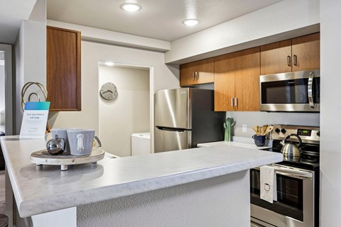 A kitchen with a stainless steel refrigerator and microwave.