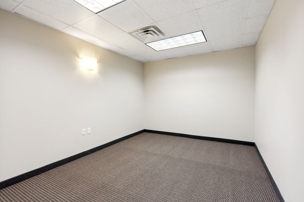 an empty room with a carpeted floor and a white wall