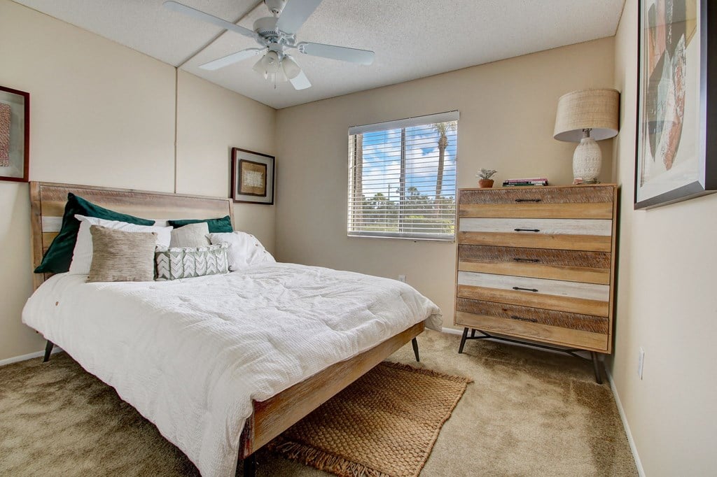Derby Park Apartments in Daytona Beach, FL photo of a bedroom with a bed and a ceiling fan
