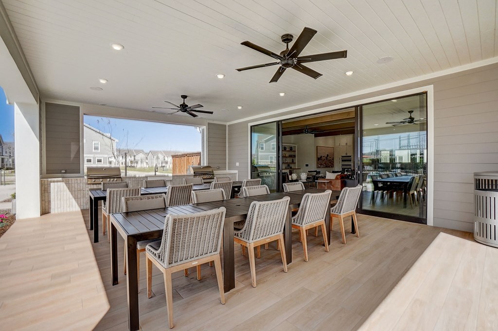 a large dining area with a large table and chairs and a ceiling fan