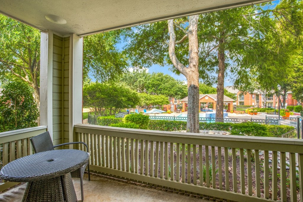 a patio with a table and chairs and a large window
