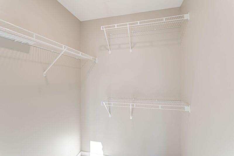 an empty closet with two white shelves on the wall