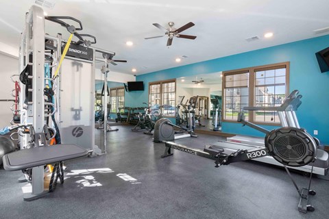 a home gym with weights and a ceiling fan