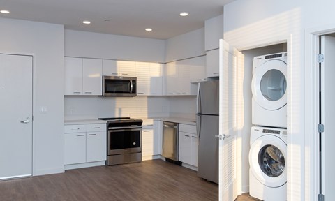 A modern kitchen with white cabinets and appliances.