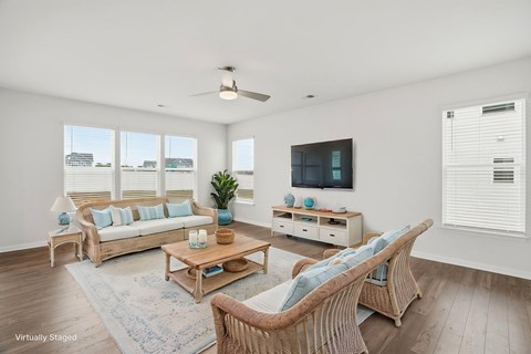 A living room with a white ceiling and a television on the wall.