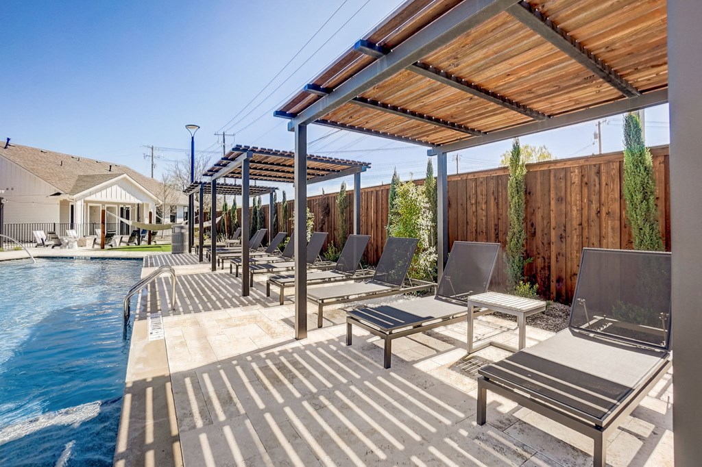 a row of lounge chairs next to a swimming pool