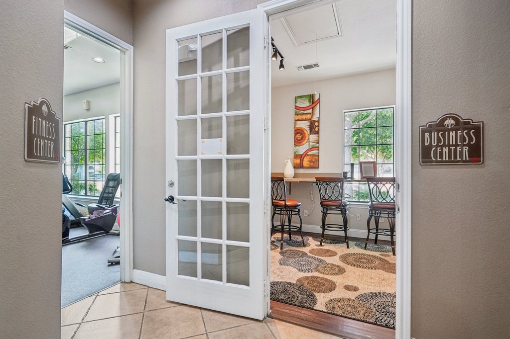 A white door with a glass panel is open to a room with a brown rug on the floor.