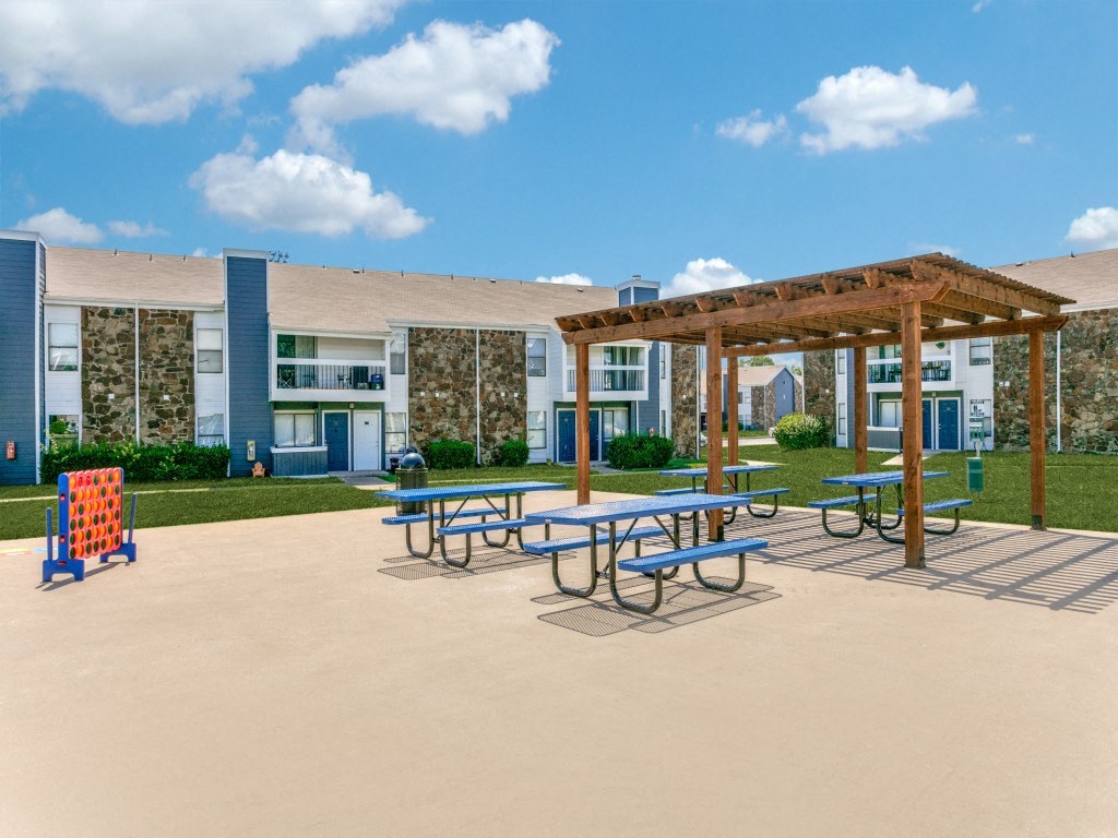 a picnic area with picnic tables and benches in front of a building