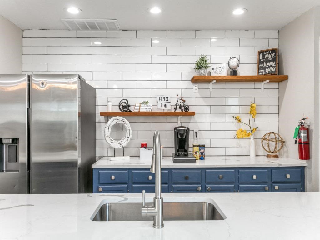 a kitchen with white countertops and blue cabinets