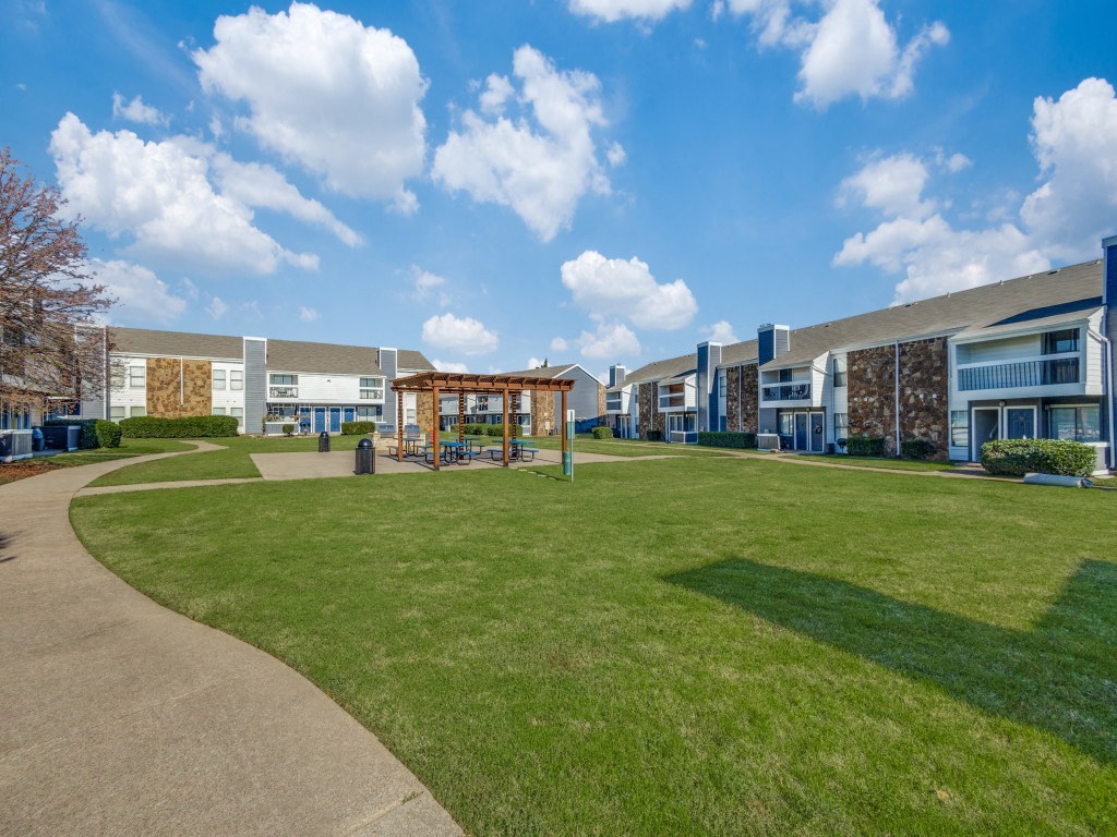 a park with a playground in front of some apartment buildings