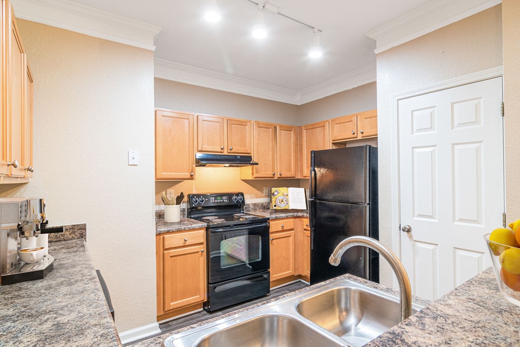 Classic kitchen with black appliances at The Asher at Sugarloaf, a pet-friendly community in Lawrenceville, GA, near Duluth.