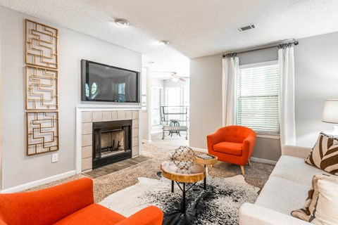 a living room with a fireplace and orange furniture