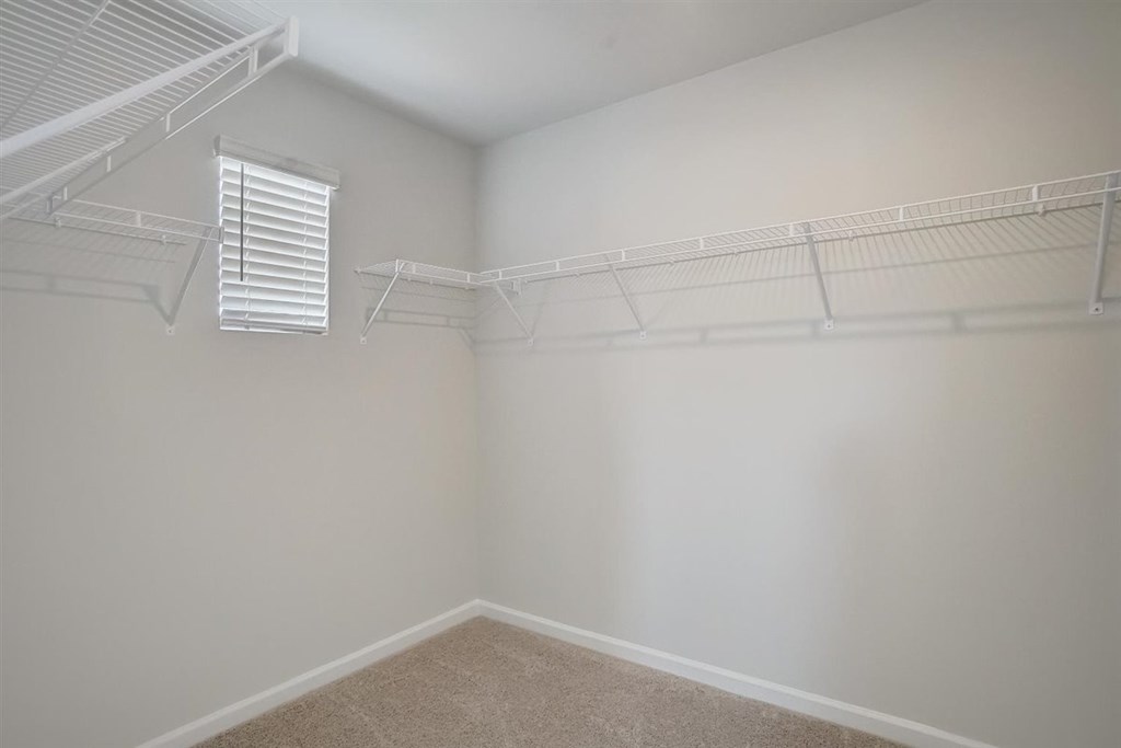 Empty room with white walls and a window with blinds.