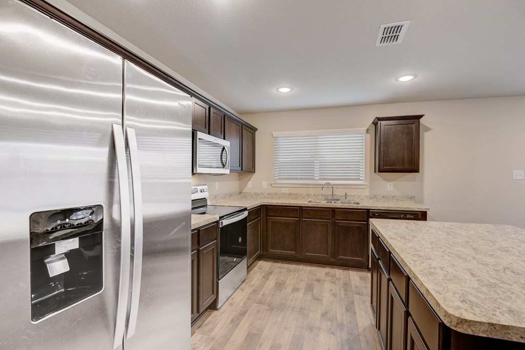 an updated kitchen with stainless steel appliances and marble counter tops