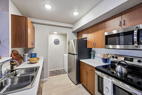 A modern kitchen with wooden cabinets and stainless steel appliances.