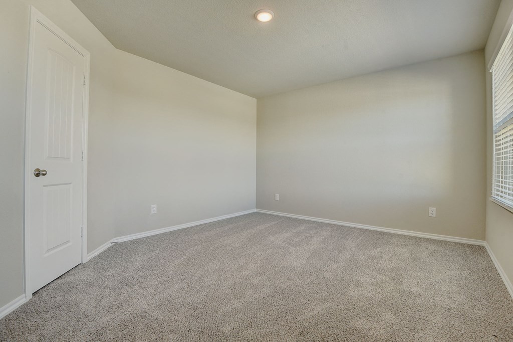 an empty living room with white walls and carpet