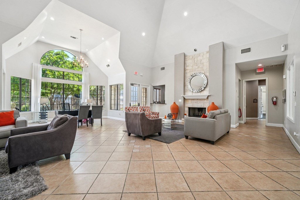 A spacious living room with a fireplace and a large mirror on the wall.