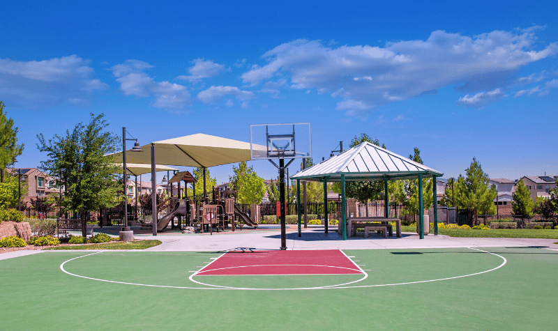 a basketball court and gazebo at a playground in a park