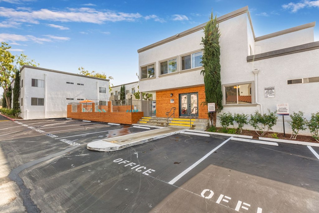 a large white building with a parking lot in front of it