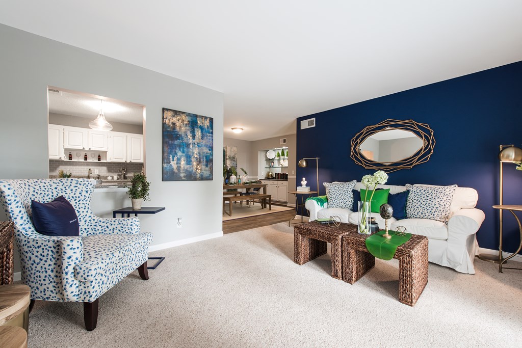 Pet-Friendly Apartments in Sandy Springs – Celebration at Sandy Springs - a living room with a blue accent wall and a white couch