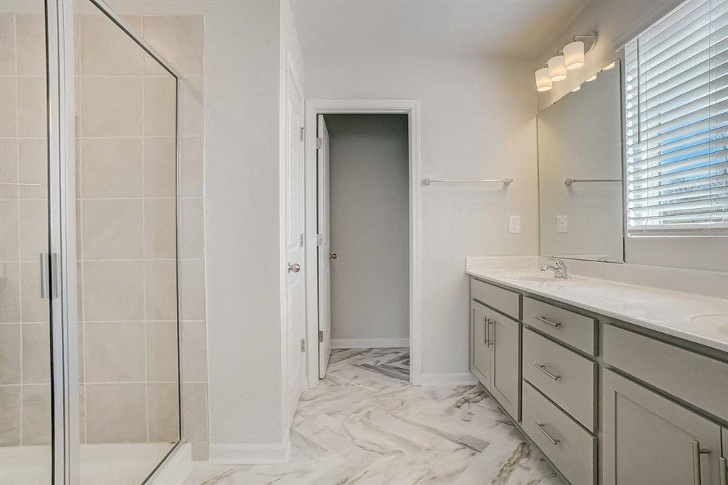 a bathroom with a large mirror and a walk in shower