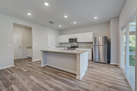 a kitchen with a large island and stainless steel appliances
