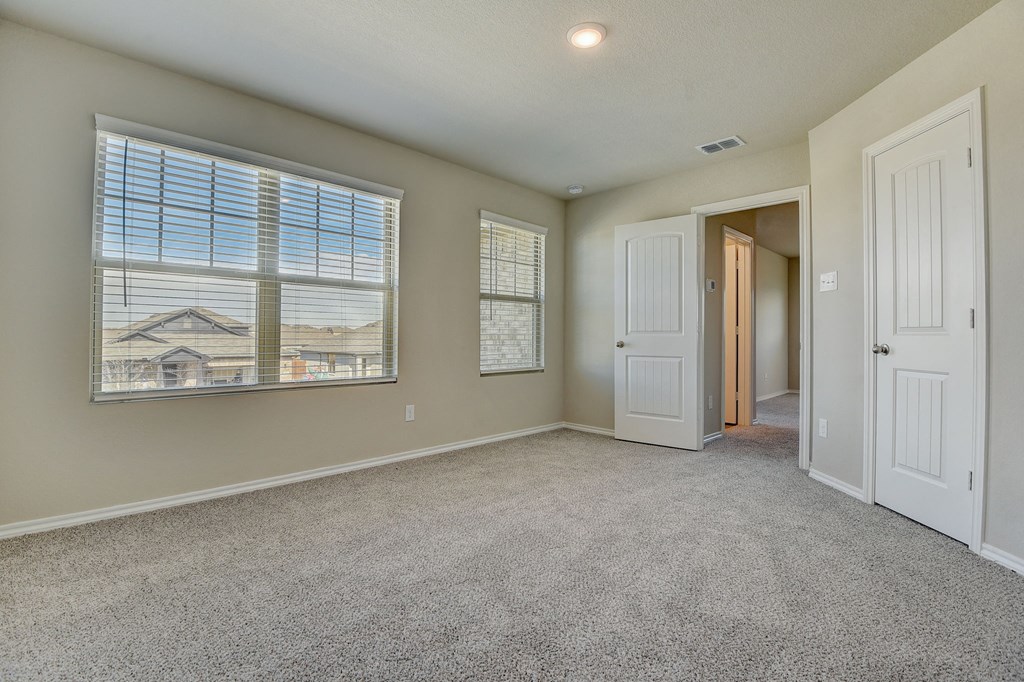 an empty living room with a large window and a door