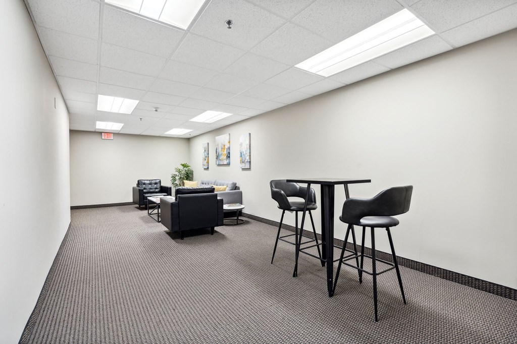 an empty room with chairs and a table in the middle